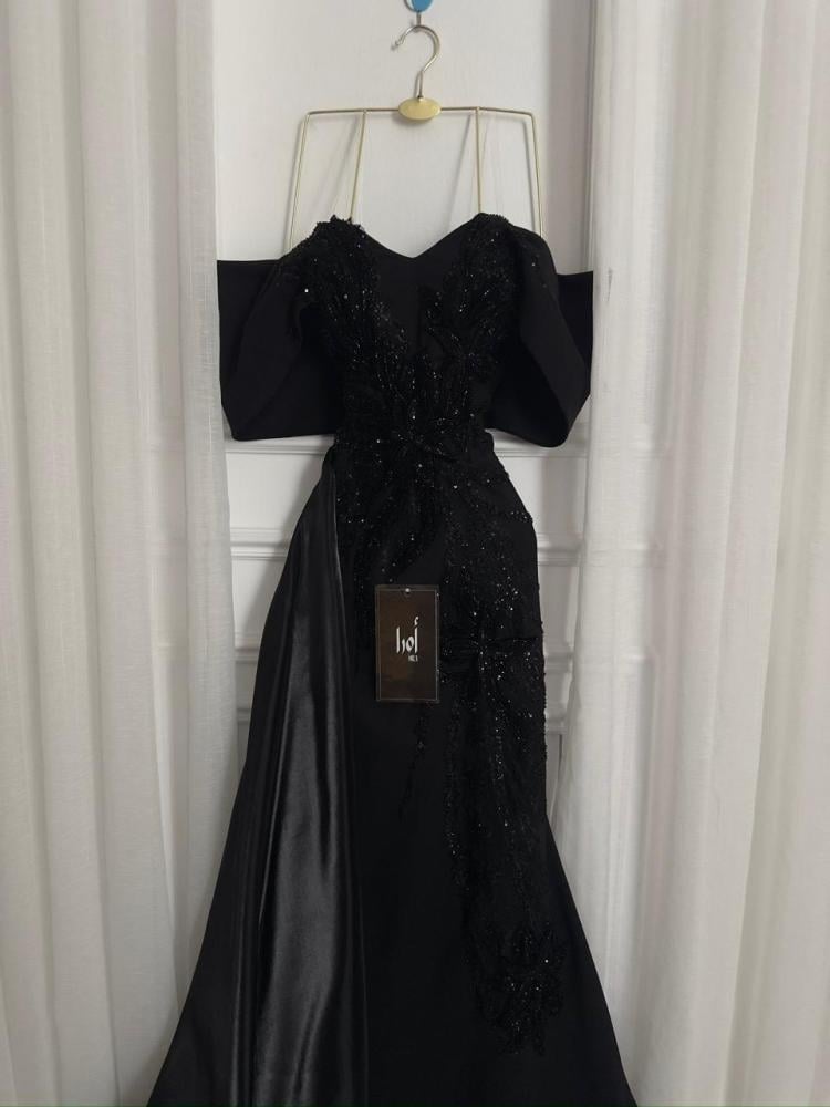 A black dress with elegant trim and a Barbie-style butcher's tail with a sheen.