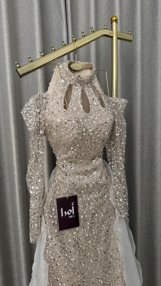 Beige evening dress with sequin embellishments and a pleated train.