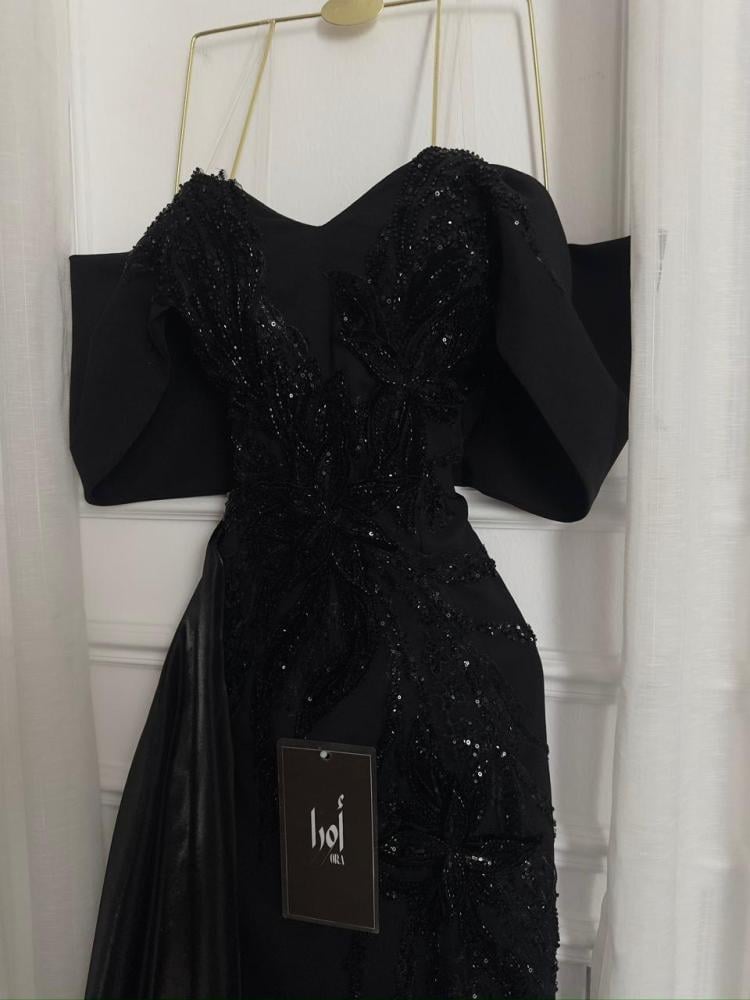 A black dress with elegant trim and a Barbie-style butcher's tail with a sheen.