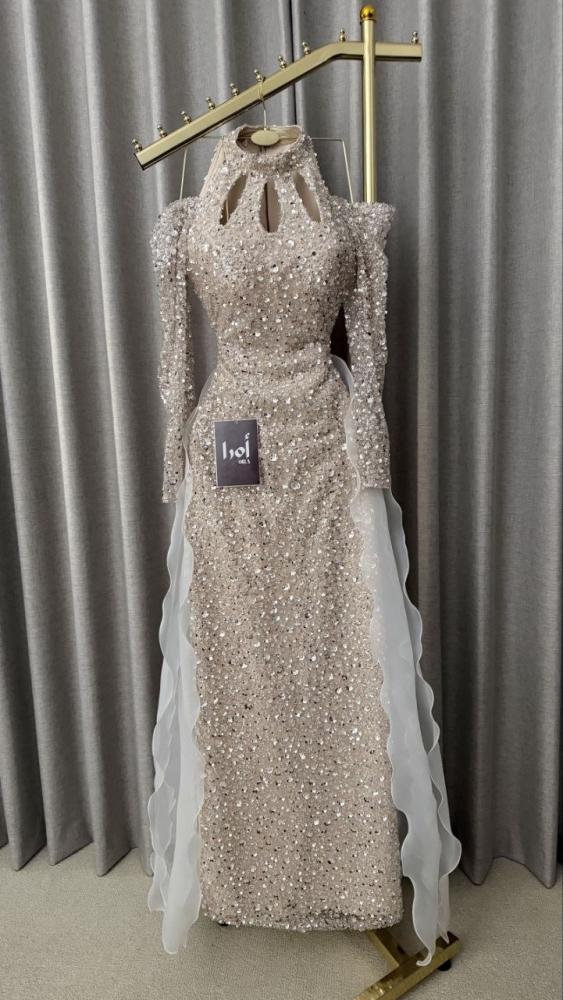 Beige evening dress with sequin embellishments and a pleated train.