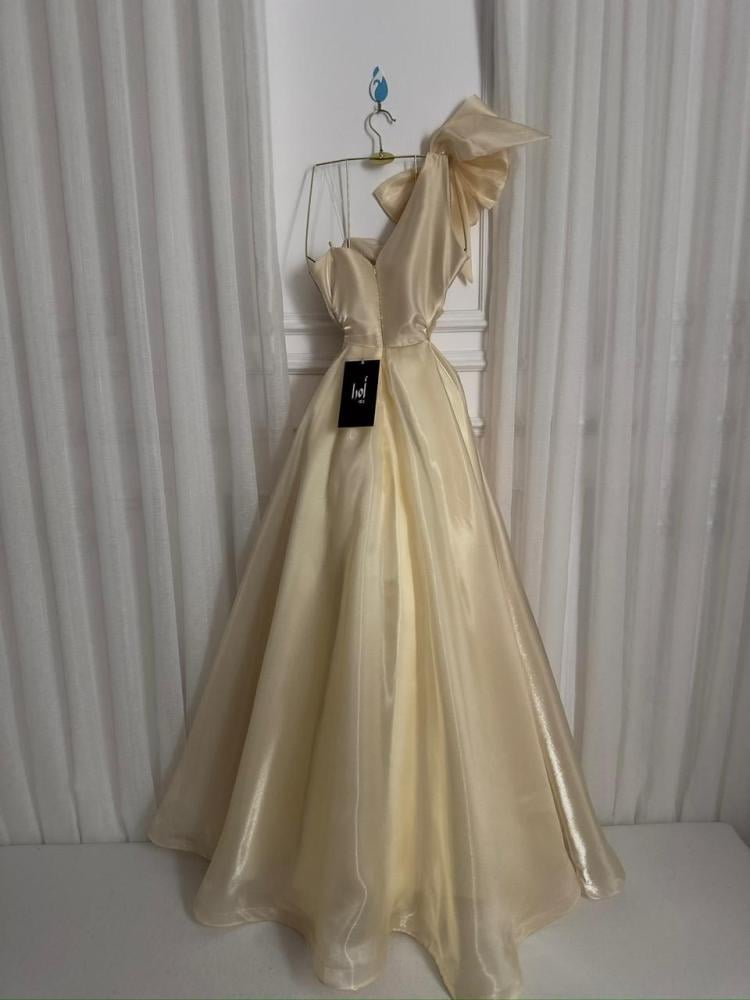 Beige butcher dress with a sophisticated sheen and a shoulder detail.