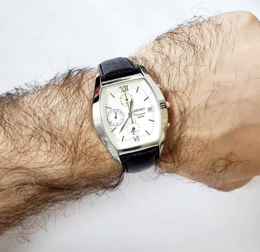 ساعة سيكو كرونوغراف الفاخرة ( منبه )صناعة اليابان (Hardlex Crystal )ضد الماء 50متر بتاريخ مينا ابيض بحزام جلد طبيعي فاخر باللون الاسود للرجال فنتج - SNA731J1