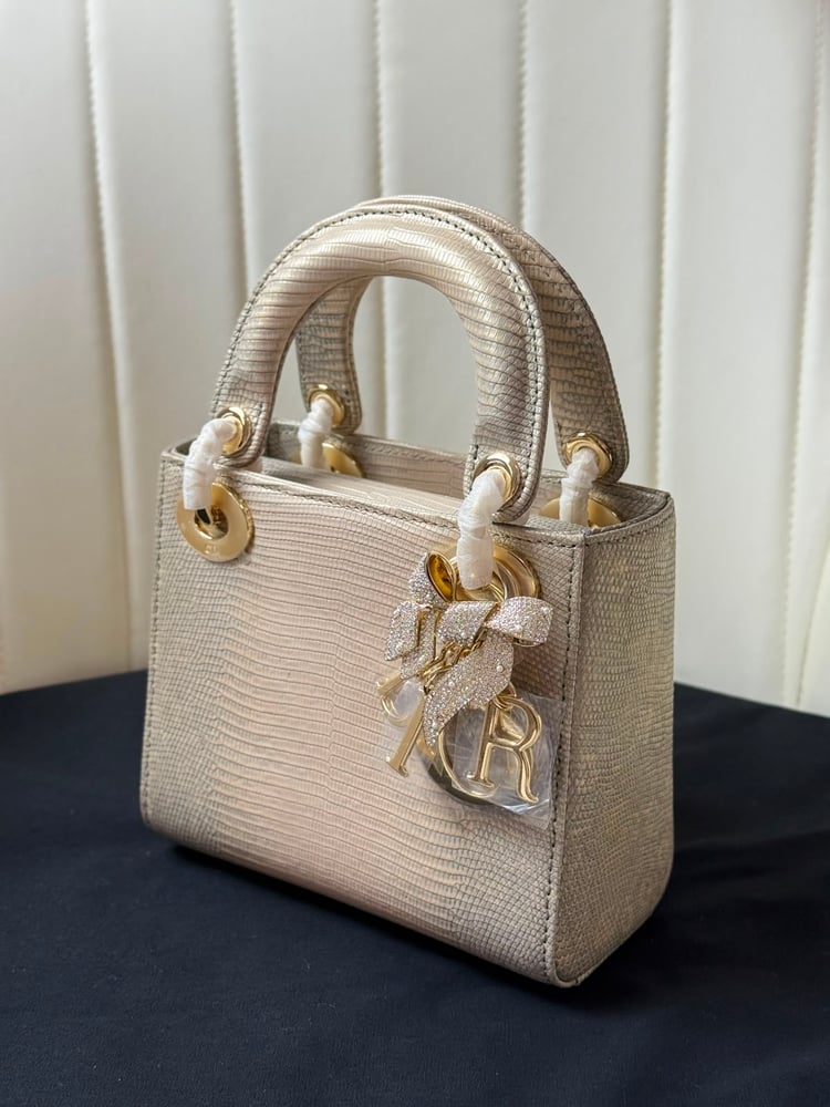 حقيبة ديور (Dior) النسائية الفاخرة بتصميم جلد السحالي مع تعليقة الفيونكة المرصعة