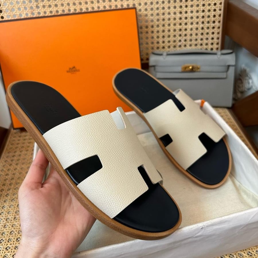 نعال إيزمير (Izmir) الصيفي الفاخر من هرمز (Hermès) من الجلد الطبيعي المحبب باللونين العاجي والأسود.