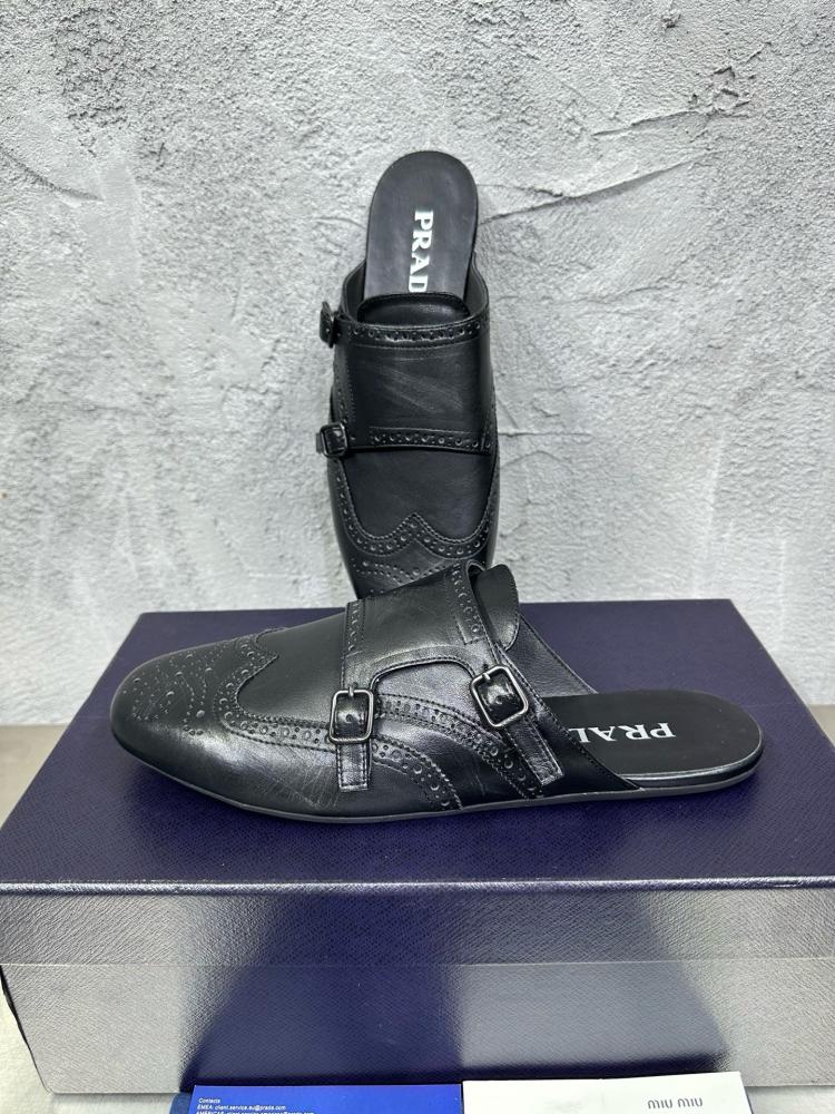 حذاء ميول (Double Monk Strap Mules) كاجوال فاخر بتصميم بروغ من برادا (Prada) من الجلد الطبيعي باللون الأسود الملكي.