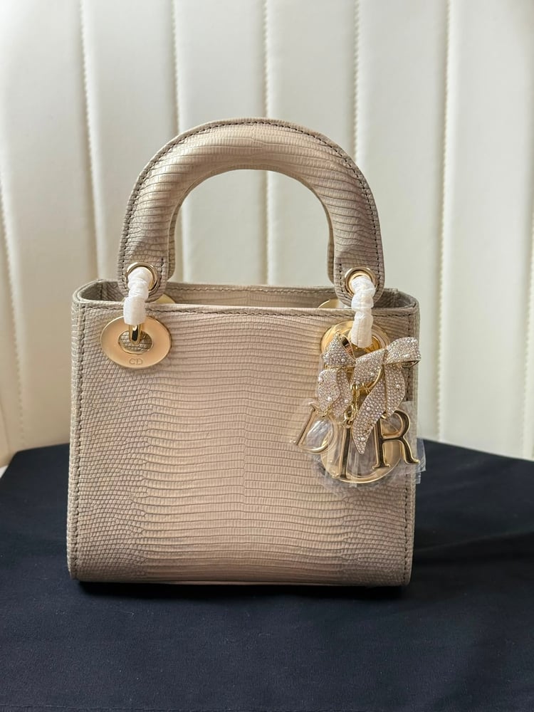 حقيبة ديور (Dior) النسائية الفاخرة بتصميم جلد السحالي مع تعليقة الفيونكة المرصعة