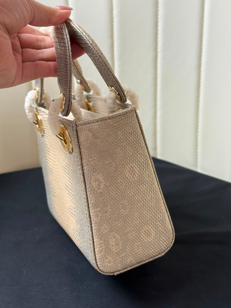 حقيبة ديور (Dior) النسائية الفاخرة بتصميم جلد السحالي مع تعليقة الفيونكة المرصعة