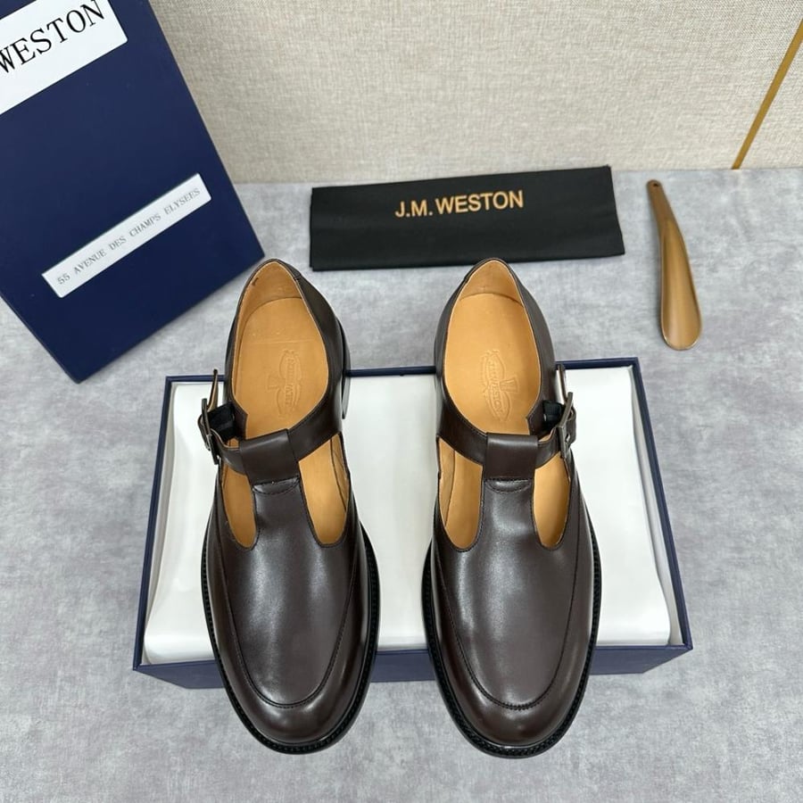 حذاء جزمة كلاسيكي فاخر بتصميم حزام T-Strap من جي إم ويستون (J.M. Weston) من الجلد الطبيعي باللون البني الشوكولاتة الداكن.