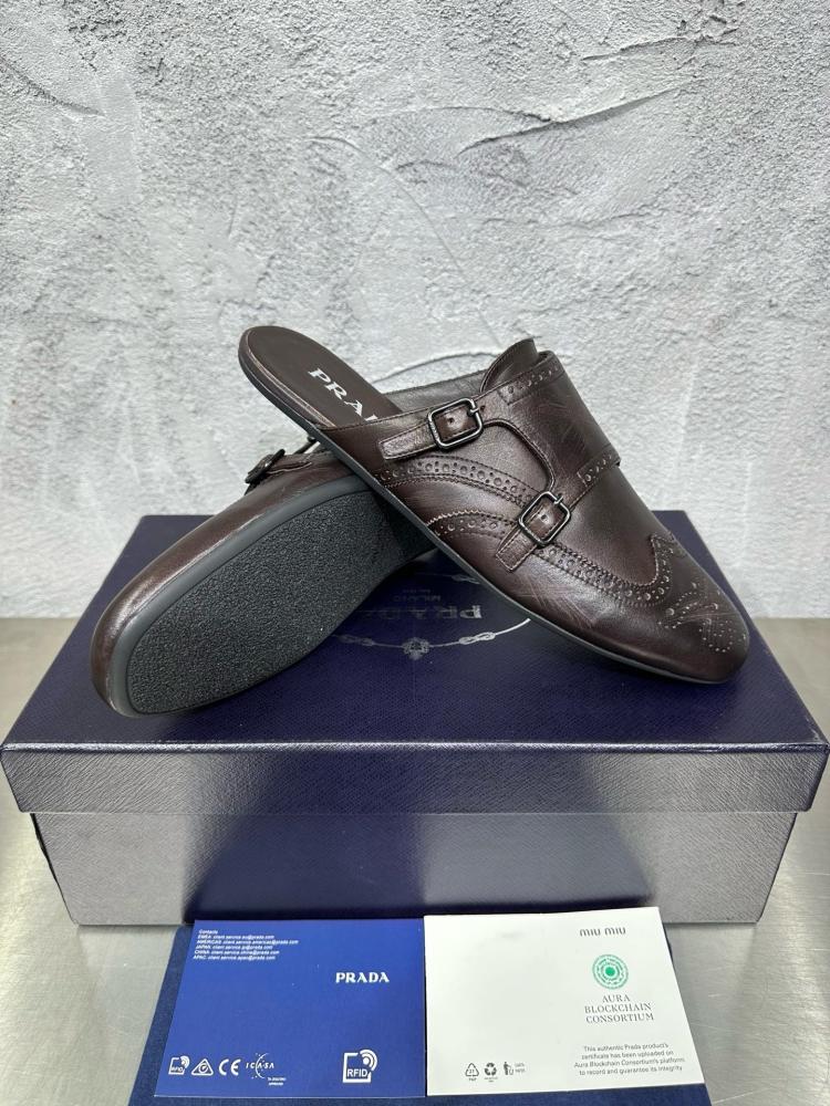 حذاء ميول (Double Monk Strap Mules) كاجوال فاخر بتصميم بروغ من برادا (Prada) من الجلد الطبيعي باللون البني المحروق.