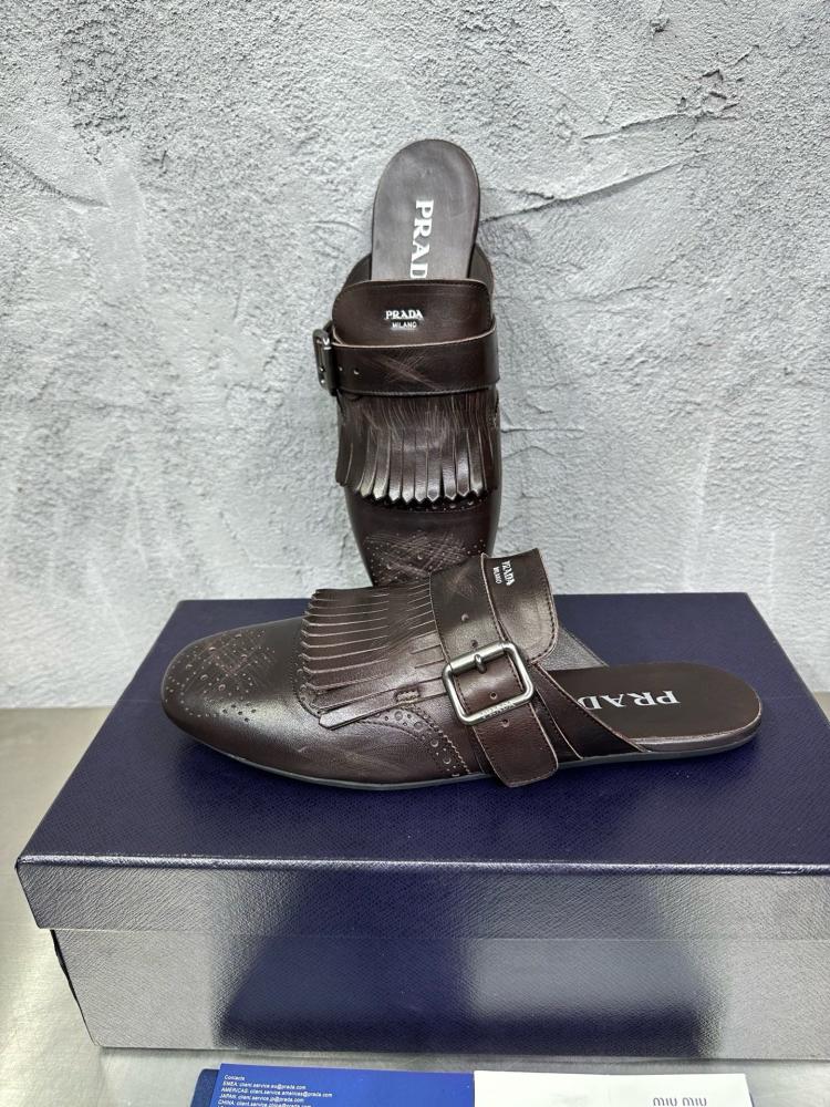 حذاء ميول (Mules) كاجوال فاخر بتصميم بروغ من برادا (Prada) من الجلد الطبيعي باللون البني المحروق.