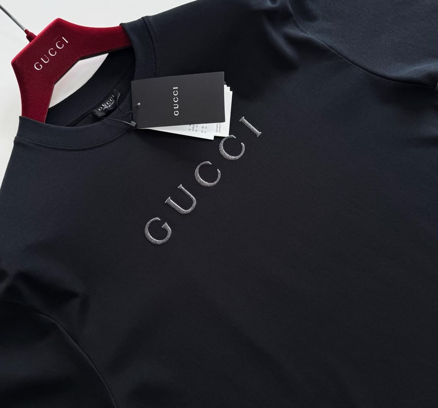 تيشرت "قوتشي" (Gucci) الرجالي الأسود بتطريز الشعار الفضي البارز