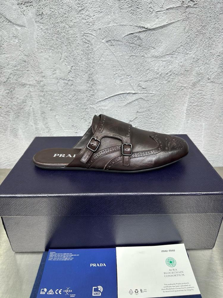 حذاء ميول (Double Monk Strap Mules) كاجوال فاخر بتصميم بروغ من برادا (Prada) من الجلد الطبيعي باللون البني المحروق.