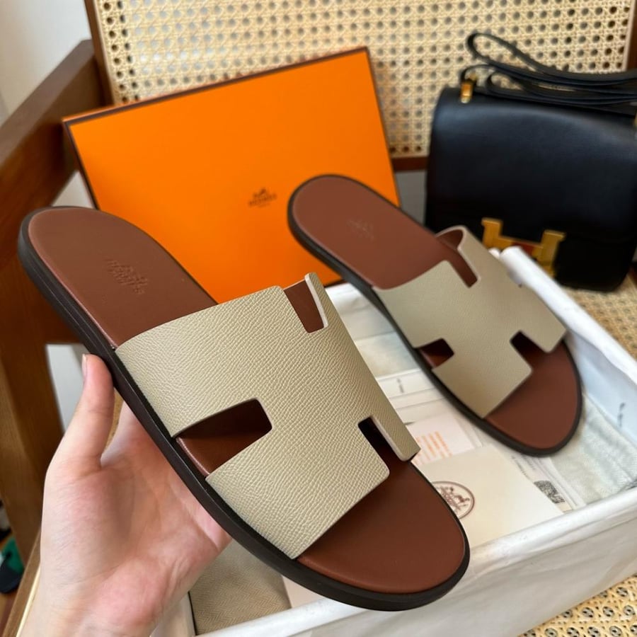 نعال إيزمير (Izmir) الصيفي الفاخر من هرمز (Hermès) من الجلد الطبيعي المحبب باللونين البيج التان والهافان.