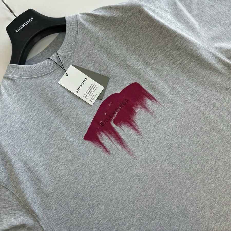 تيشرت "بالنسياغا" (Balenciaga) الرجالي الرمادي بتصميم البقعة الفنية (Paint Splash/Drip Logo)