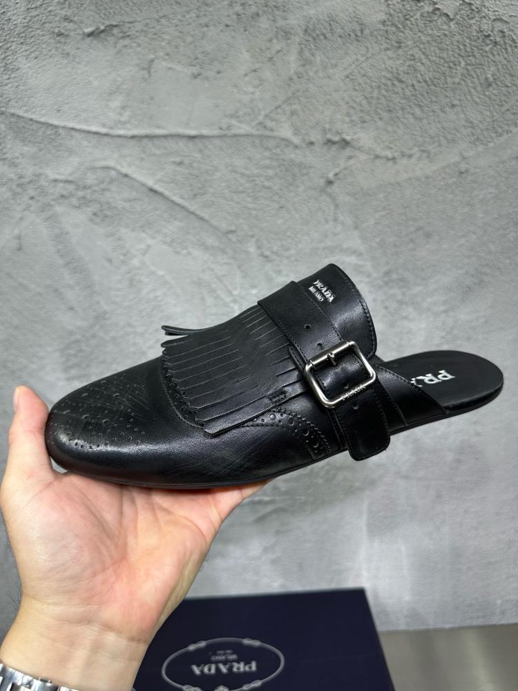 حذاء ميول (Mules) كاجوال فاخر بتصميم بروغ من برادا (Prada) من الجلد الطبيعي باللون الأسود الملكي.