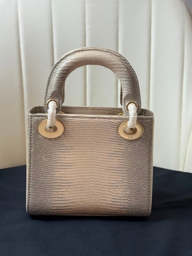حقيبة ديور (Dior) النسائية الفاخرة بتصميم جلد السحالي مع تعليقة الفيونكة المرصعة