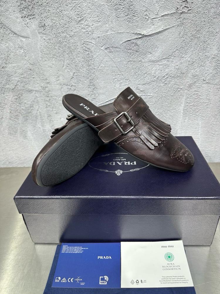 حذاء ميول (Mules) كاجوال فاخر بتصميم بروغ من برادا (Prada) من الجلد الطبيعي باللون البني المحروق.