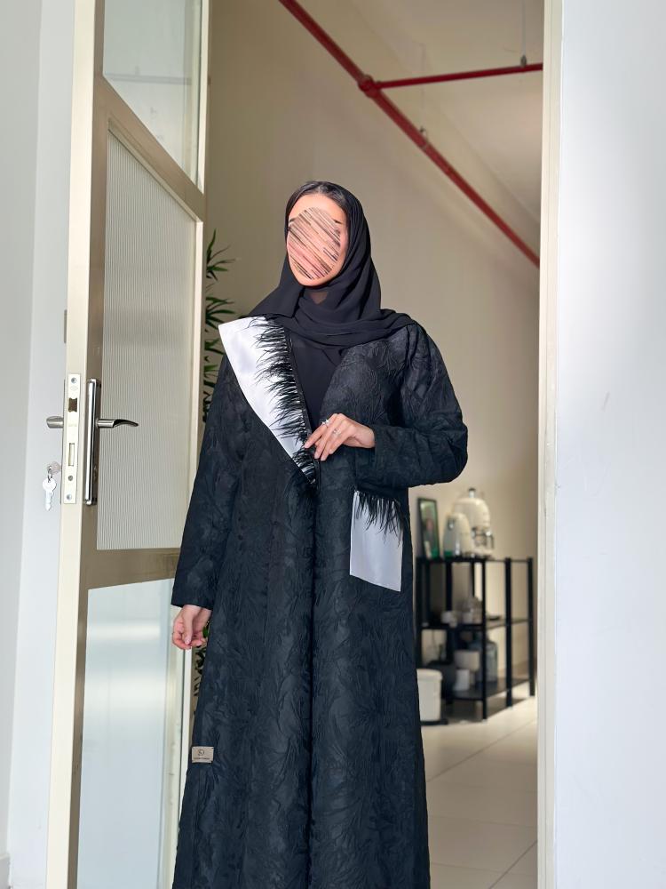 عباية من قماش التفتة المشجر ، مزينة بريش وتداخل اللون الرمادي لإطلالة عصرية فاخرة