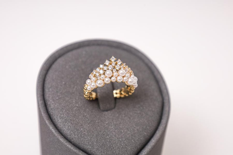 Gold ring with a crown design made of small spherical circles