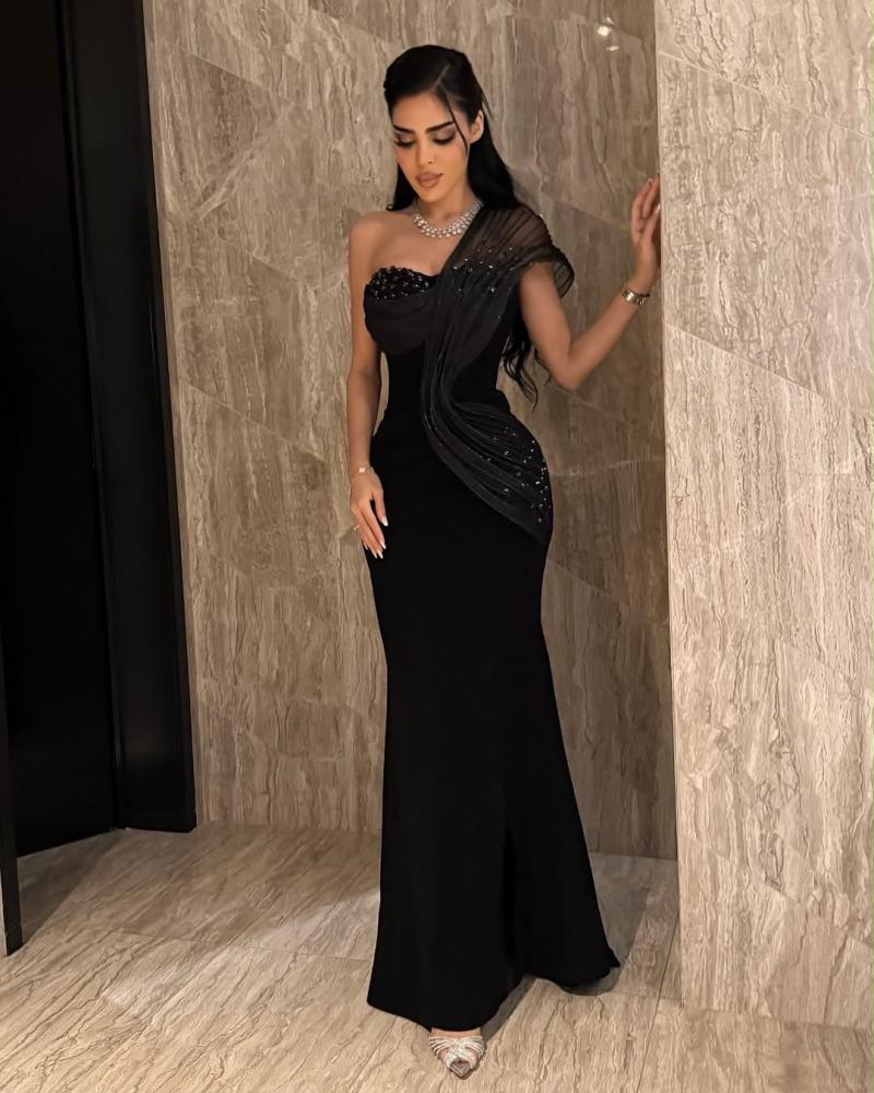 فستان أسود طويل مزين بطبقة تول شفافة مرصعة بالترتر