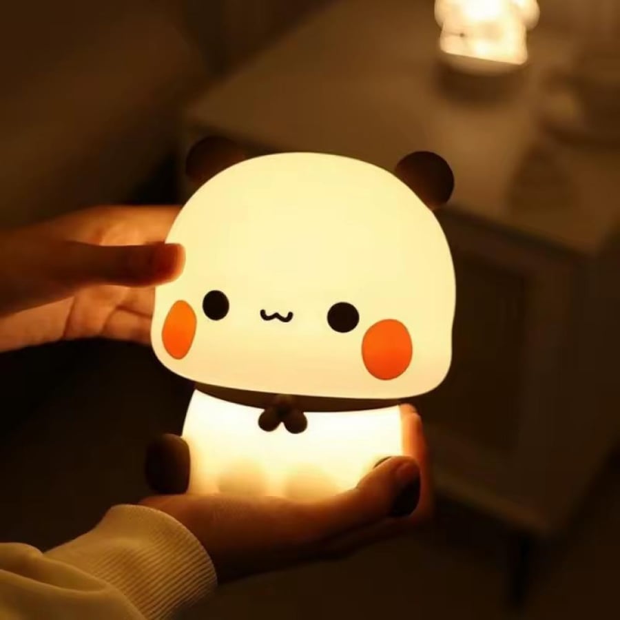 مصباح ليلي لطيف على شكل باندا. يتميز بتصميم ناعم ومستدير مع جسم مضيء ينبعث منه ضوء دافئ.
