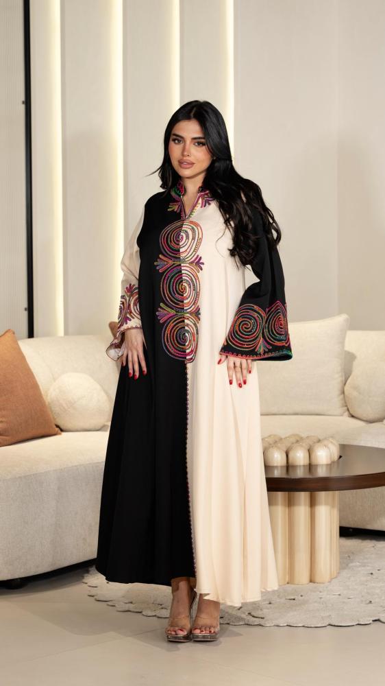 A traditional men's garment in beige and black embroidered