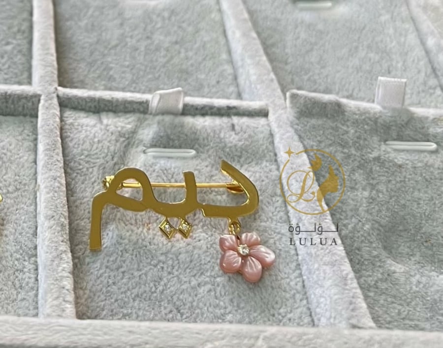 Name badge with gold plating with a bank flower
