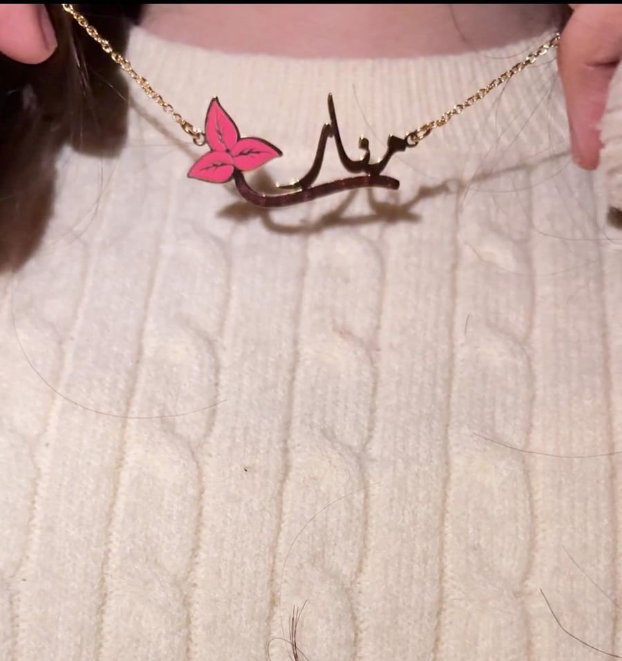 A pink necklace with a name and a distinctive design