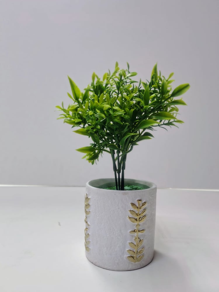 Faux Green Plant in Decorative White Pot نبات أخضر صناعي في وعاء أبيض مزخرف
