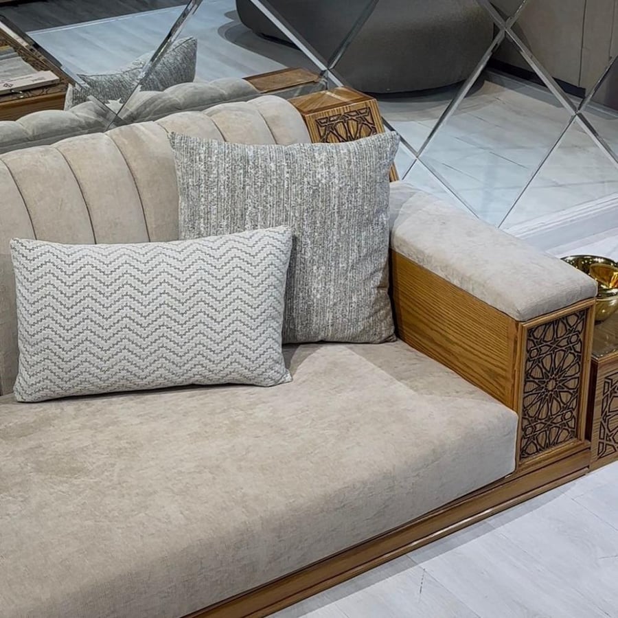 تفاصيل ذراع كنب خشبي مزخرف مع وسائد قماشية أنيقة لطقم كنب فاخر