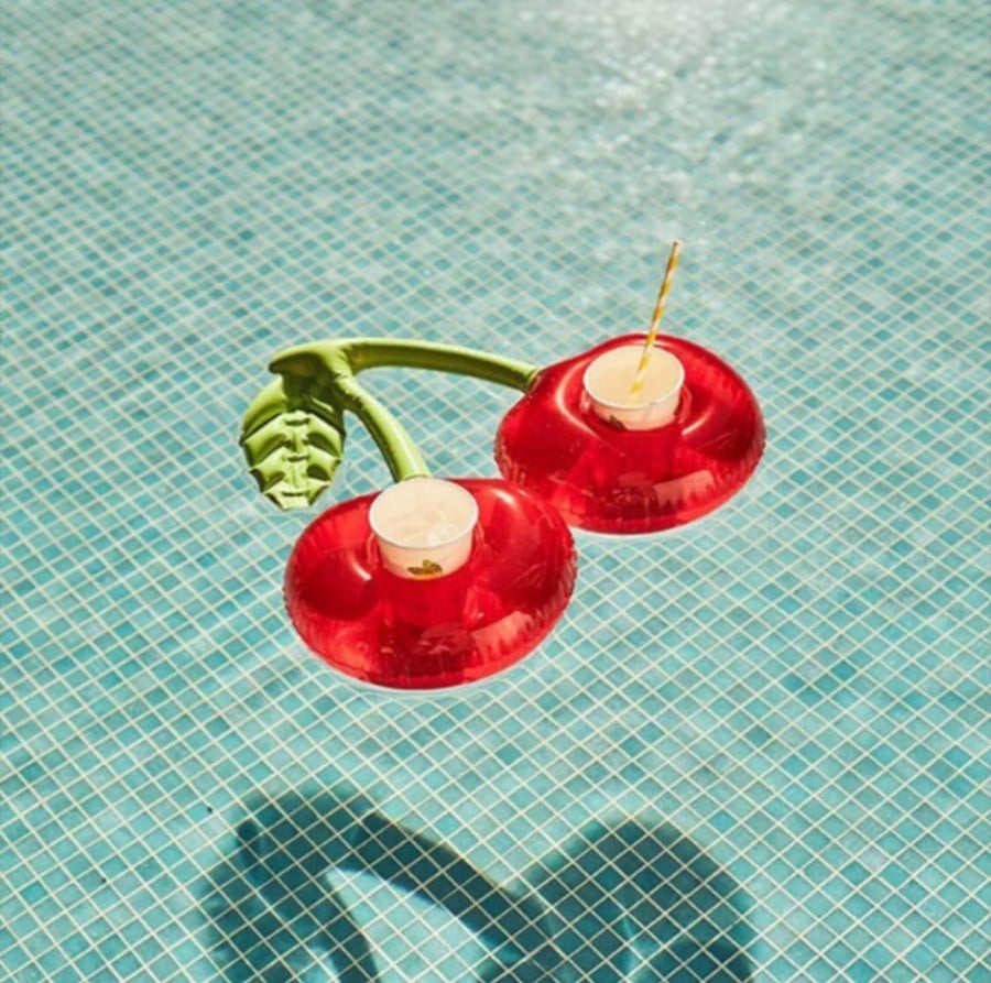 A pool cup holder in the shape of a cherry for two adjacent cups