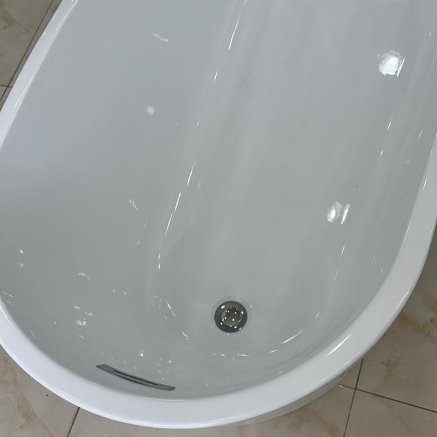 A classic white bathtub above the tiles
