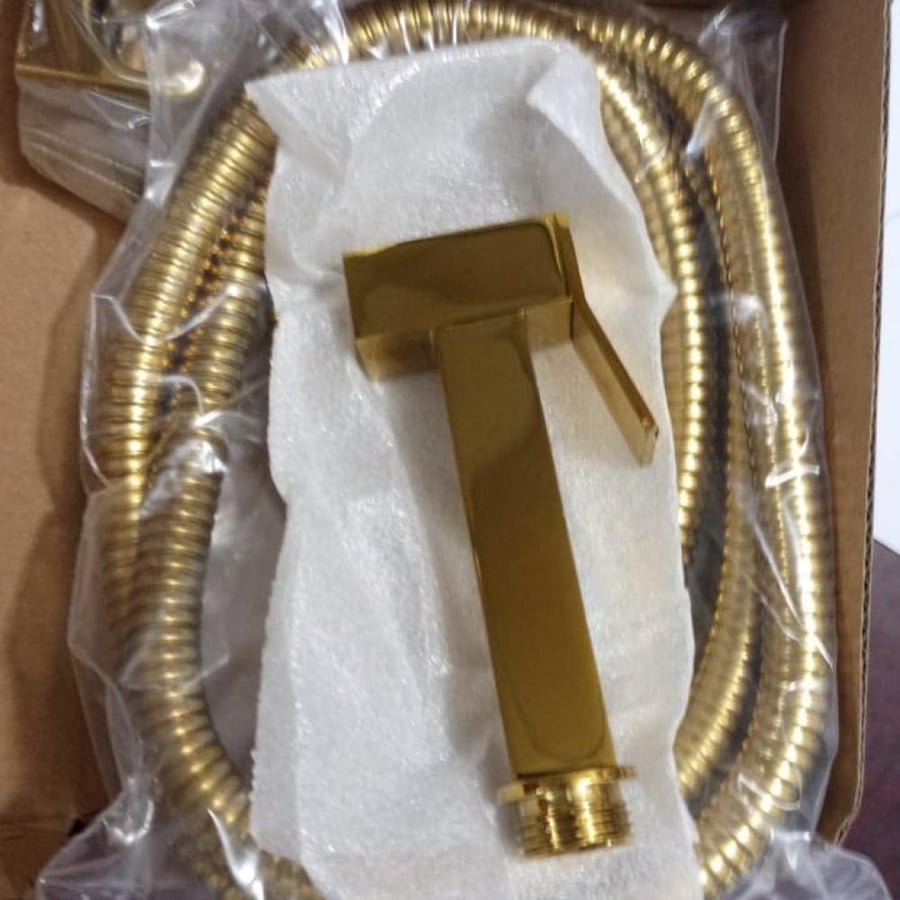 A shower head with a gold-colored handle