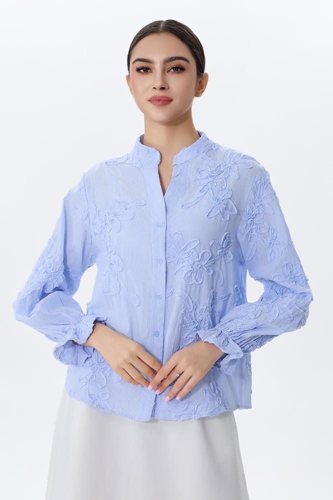 A blouse embroidered with raised flowers in sky blue color
