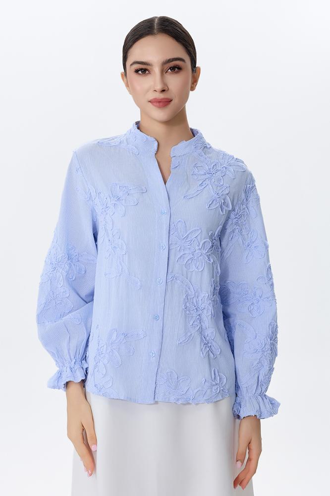 A blouse embroidered with raised flowers in sky blue color