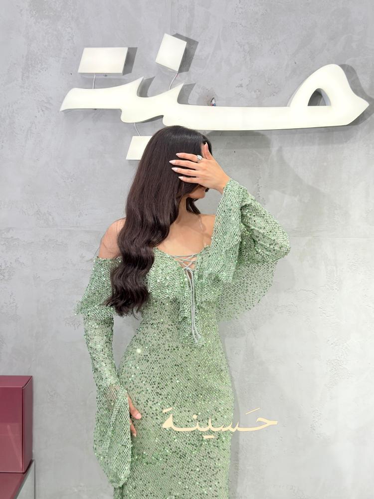 فستان أخضر لامع بأكمام طويلة واسعة