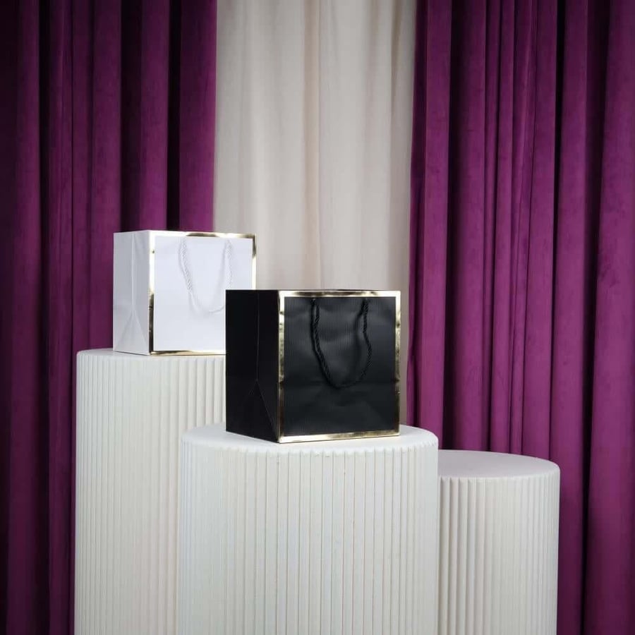 Small black and gold rectangular bags, carrying a dozen