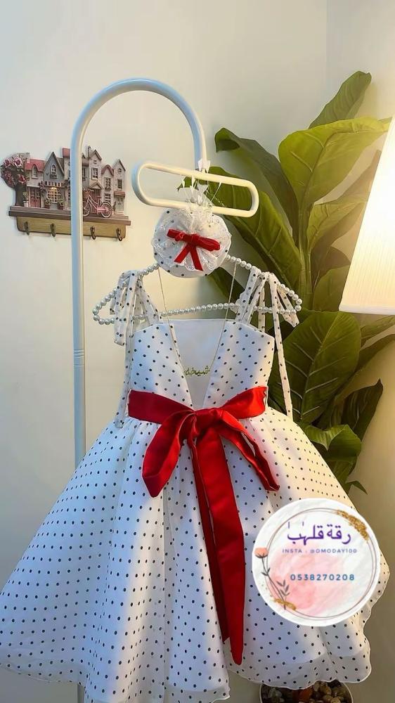 فستان منقط ابيض مع حزام احمر شامل سلسال بالاسم  اكسسوار الشعر والقفازات