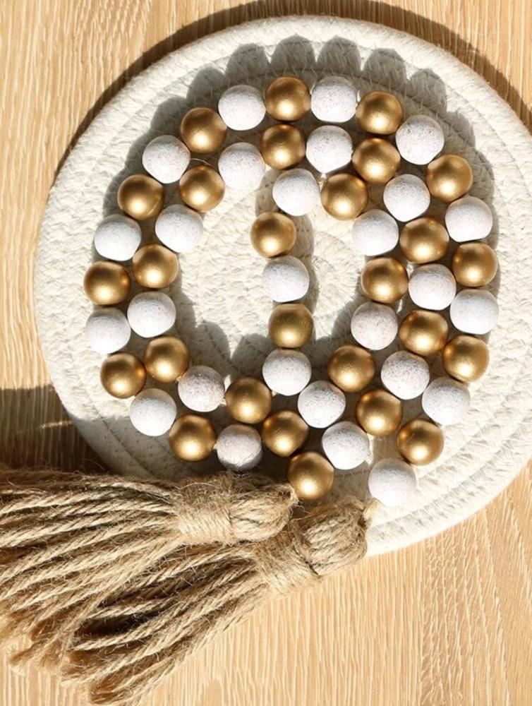 Wooden decor made of beige and gold beads finished with tassels