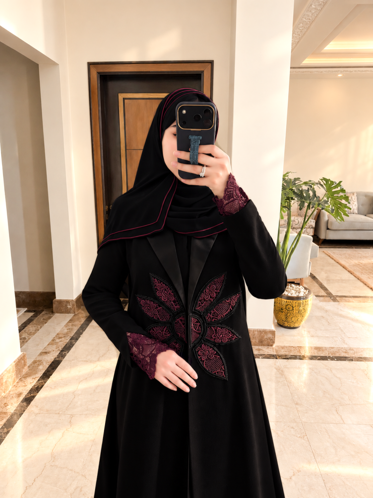 عباية من الكريب الفاخر، مزينة بالجوبير الإيطالي وتفاصيل التطريز البارز بدرجات العنابي تشمل طرحة مطرزة