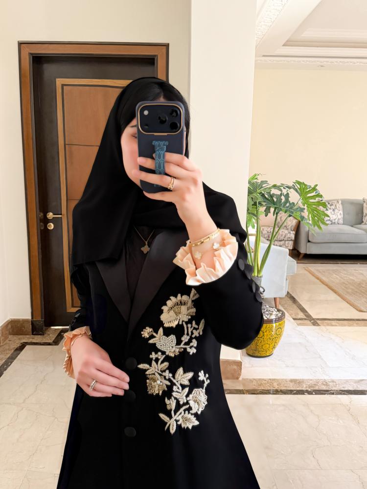 عباية بتصميم أنيق وقصّة رسمية، مصنوعة من الكريب الملكي الفاخر، ومزيّنة بتفاصيل تطريز دقيقة وشك يدوي باللؤلؤ يضفي عليها لمسة فاخرة وراقية