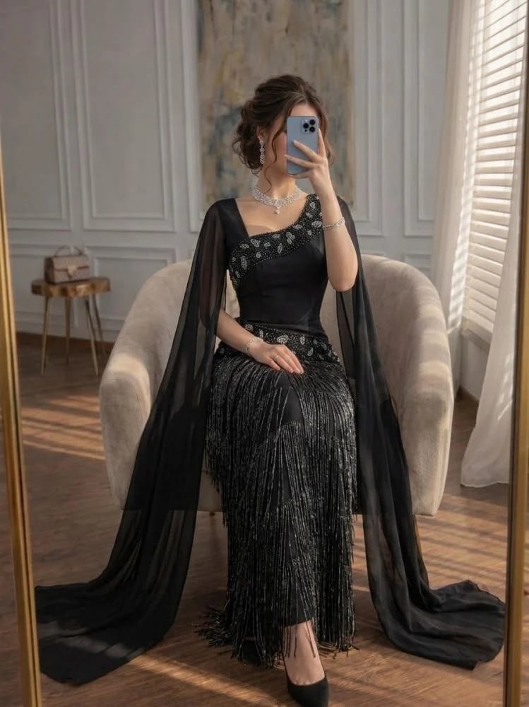 فستان سهرة أسود ملكي بكتف مائل مع أكمام كاب طويلة وهدب لامع