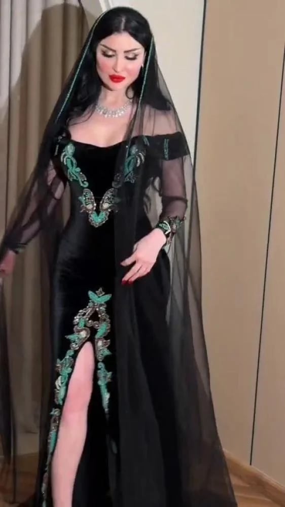 فستان سهرة أسود كولوم مخمل كوري بتطريز يدوي فيروزي بفتحة أمامية وطرحة كاب تل ملكية