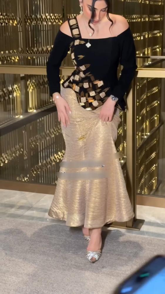 فستان سهرة قطعتين أسود وذهبي – أكتاف مكشوفة بتطريز هندسي وتنورة بليسيه