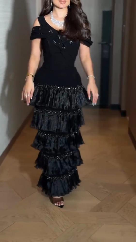 فستان سهرة أسود كولوم باربي بأكتاف جورجيت مروحية وتنورة طبقات أورجانزا لمعة بليسيه وكلفة سهرة