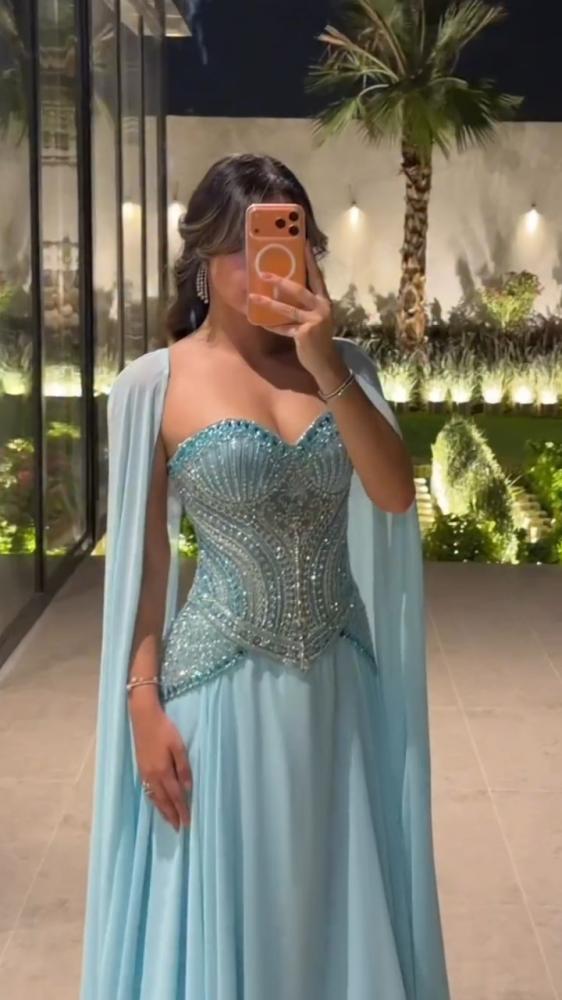 فستان سهرة جورجيت سماوي بتطريز يدوي وكاب منسدل