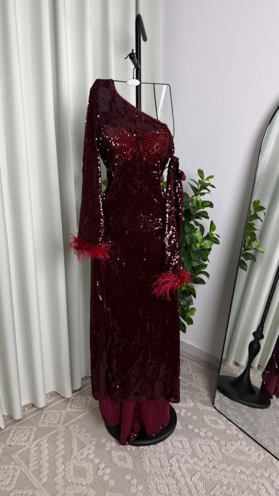 فستان سهرة عنابي بترتر لامع بقصة كتف واحد وأكمام مزينة بالريش