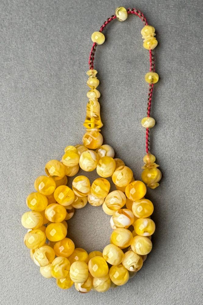 A black agate prayer bead similar to amber with a patterned appearance