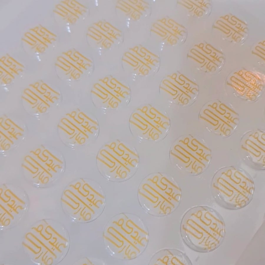 A ready sheet of 3 cm size and 6 mm depth with "Eid Mubarak" in gold color, circular shape.