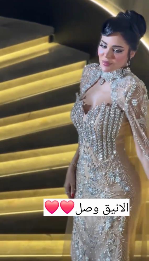 قماش ساتان مغطى بالتول المطرّز بالخرز والترتر والكريستال، بلون شامبين ذهبي مع تطريز فضي.